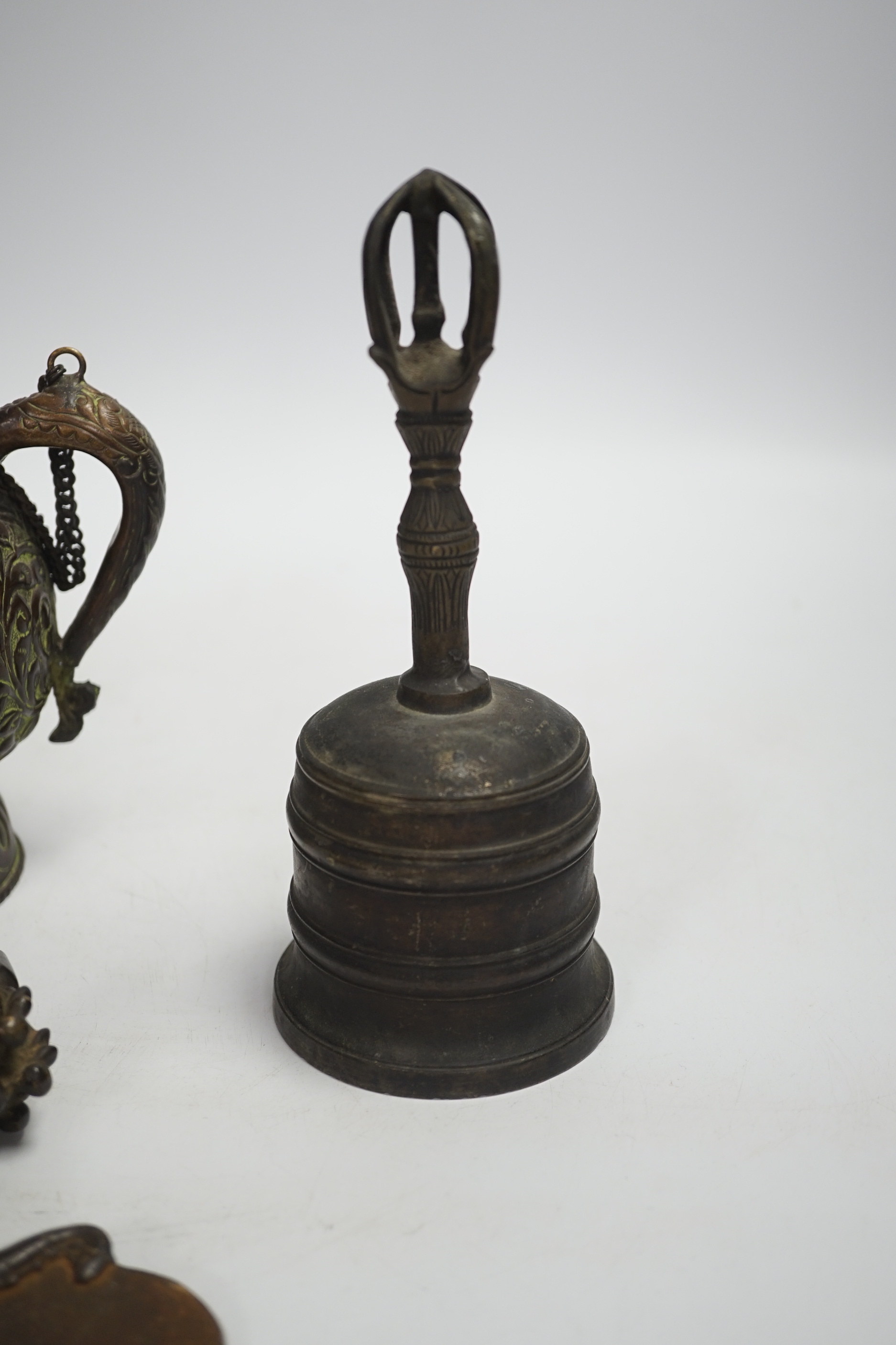 A Tibetan repousse teapot, a ghanta bell and a kartika chopper, tallest 19cm